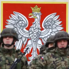 Żołnierze w mundurach stoją przed godłem Polski. Dowódca kompanii, stopień wojskowy, jest gotowy do akcji.