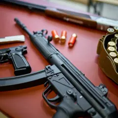 Na stole leżą pistolety, karabin i pas z amunicją. To wszystko może być częścią pozwolenia na broń obiektową.