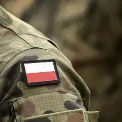 Na mundurze widoczna naszywka z flagą Polski. To symbol dumy i tradycji, nawiązujący do historii, w tym do stopni wojskowych II RP.