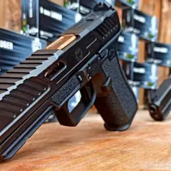 Pistolet 9 mm Luger, gotowy do użycia po uzyskaniu pozwolenia na broń. W tle pudełka z amunicją.