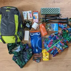 Plecak, kijki trekkingowe, bukłak i kolorowe ubrania – wszystko gotowe na wyprawę w góry.