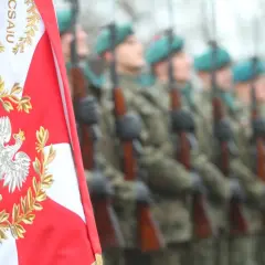 Orzeł biały na polskiej fladze i żołnierze w mundurach. Chcesz wiedzieć, jak dostać się do wojska?