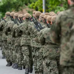 Żołnierze w kamuflażu, każdy sierżant w wojsku gotowy do akcji, maszerują w szeregu z karabinami.