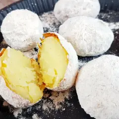 Ziemniaki pieczone w popiele, idealne co na ognisko. Jedna połówka pokazuje miękki, żółty środek.