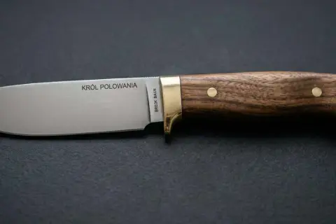 Elegancka głownia noża z napisem "KRÓL POLOWANIA" i drewnianą rękojeścią, idealna dla każdego myśliwego.