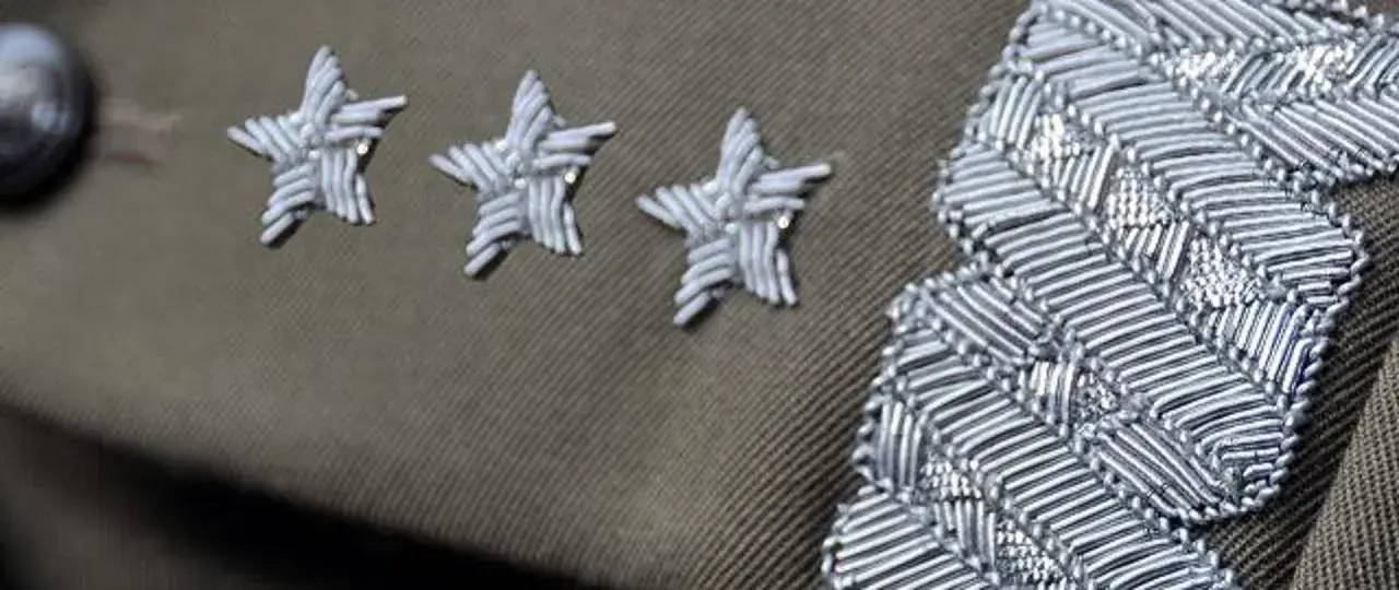 Trzy gwiazdki w wojsku, symbol wysokiej rangi, zdobią mundur obok ozdobnego naramiennika.