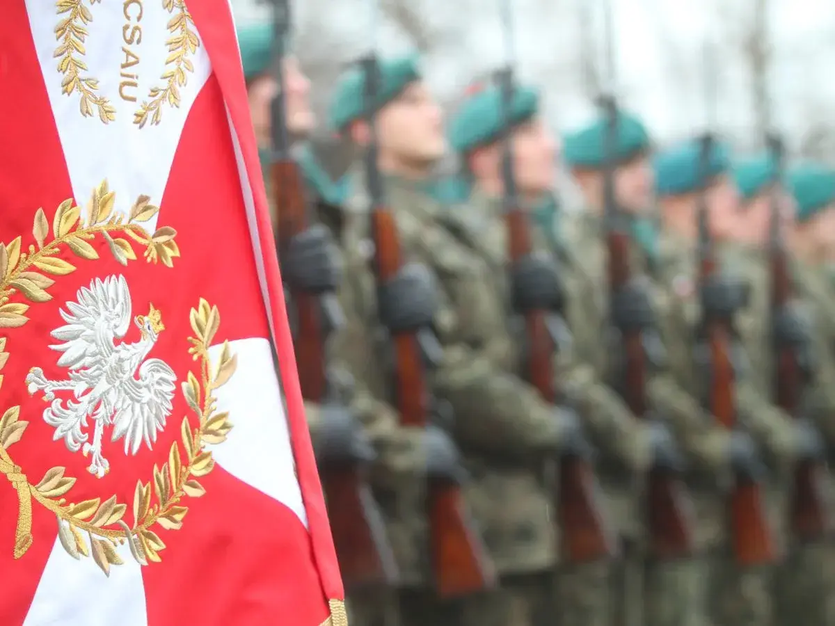 Orzeł biały na polskiej fladze i żołnierze w mundurach. Chcesz wiedzieć, jak dostać się do wojska?