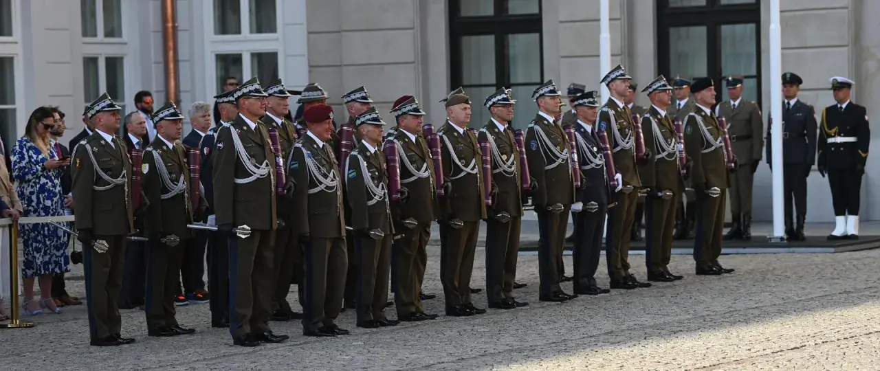 Uroczystość wręczenia nominacji na stopnie generalskie w Polsce. Wojskowi w galowych mundurach stoją w szeregu, prezentując swoje honory.