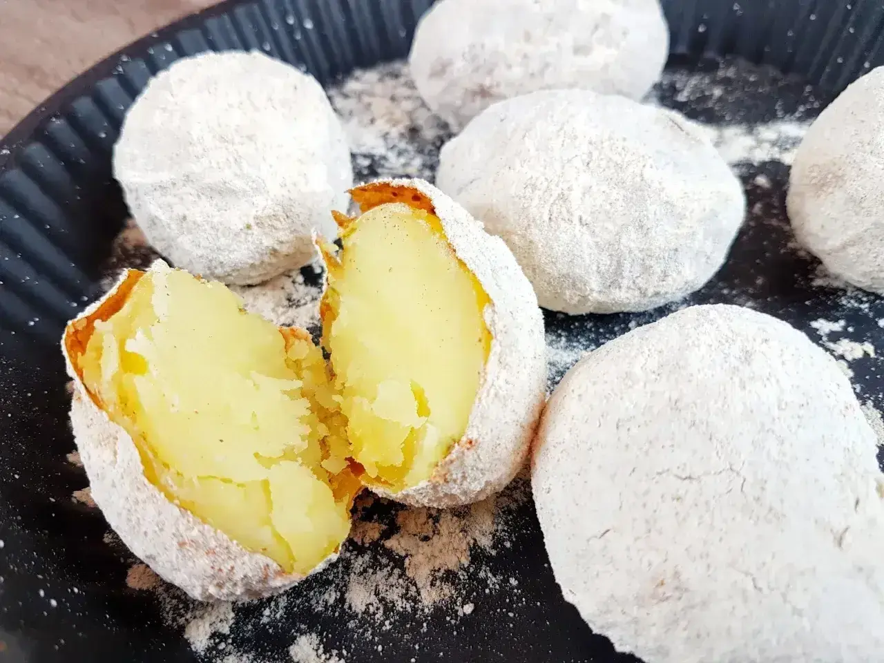Ziemniaki pieczone w popiele, idealne co na ognisko. Jedna połówka pokazuje miękki, żółty środek.