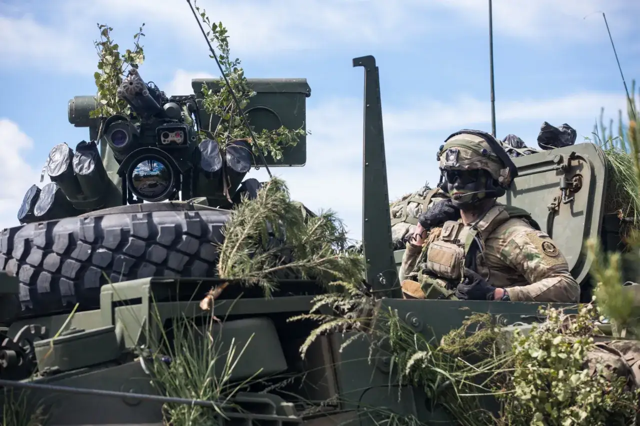 Żołnierz w hełmie i goglach w pojeździe opancerzonym podczas szkolenia specjalistycznego wojska.