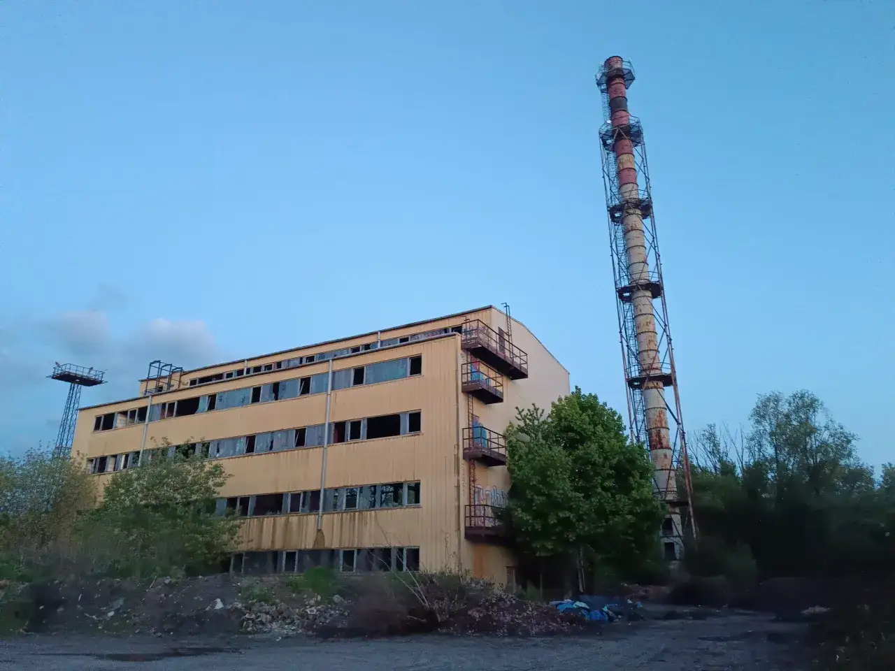 Opuszczony budynek z kominem, zniszczone okna, ślady graffiti. To miejsce idealne do eksploracji, czyli urbex.