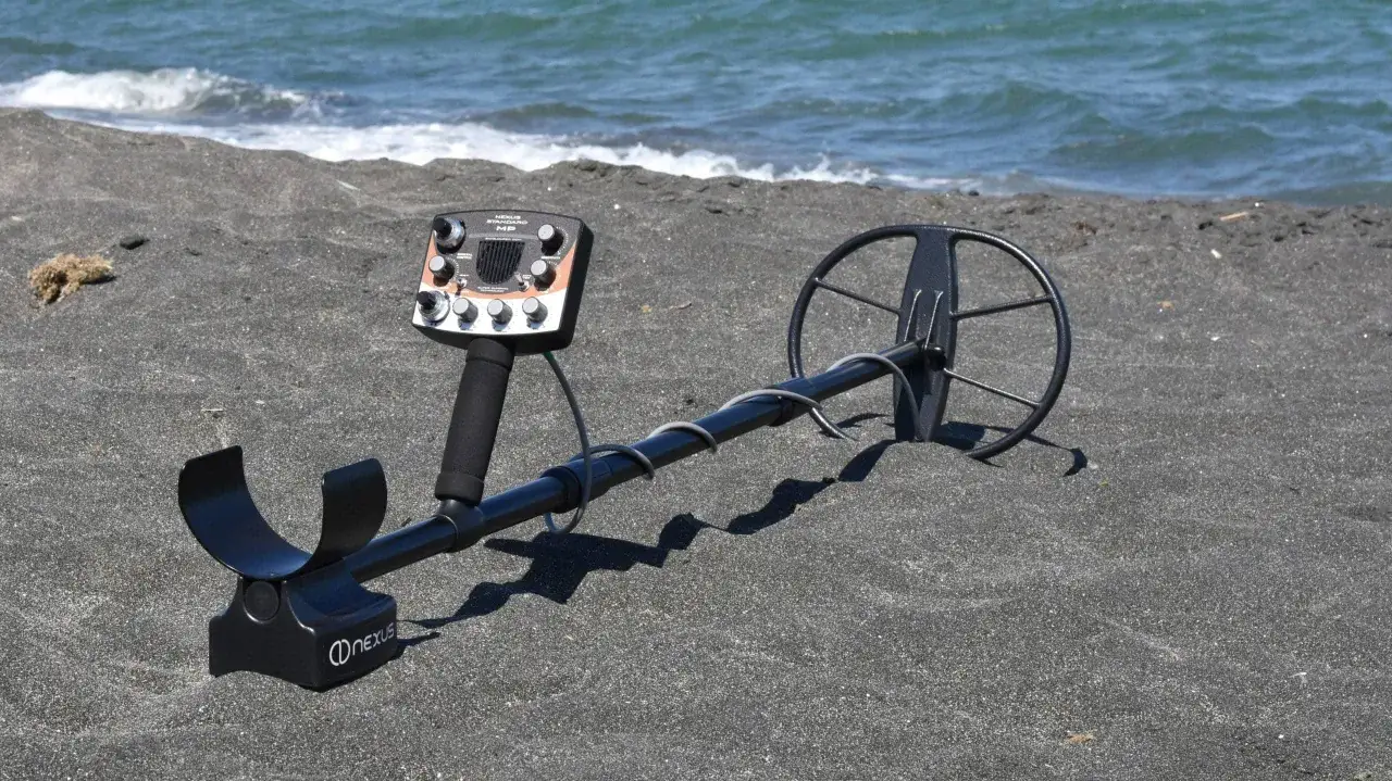 Wykrywacz metali na czarnej plaży, gotowy do poszukiwań. Czy można chodzić z wykrywaczem po plaży? Tak, to świetne miejsce na znaleziska!