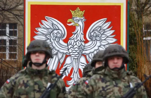 Żołnierze w mundurach stoją przed godłem Polski. Dowódca kompanii, stopień wojskowy, jest gotowy do akcji.
